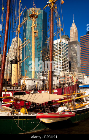 Mâts et vergues de vieux navires à voile avec les immeubles de Lower Manhattan au-delà, la ville de New York, USA Banque D'Images