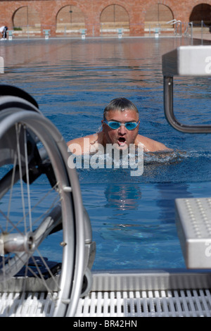 Les jeunes, l'homme handicapé, utilisateur de fauteuil roulant, natation exercices dans une piscine, la brasse Banque D'Images