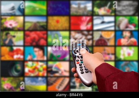 Gros plan d'une main tenant une télécommande avec un concept de télévision. Banque D'Images