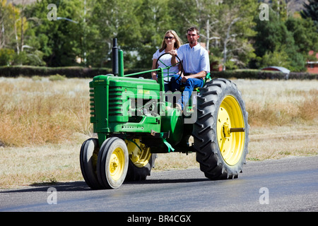 Newlywed couple marié à cheval sur un tracteur dans leur cortège nuptial de l'église à la réception, Salida, Colorado Banque D'Images