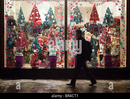 Une vitrine de l'affichage à Noël avec une personne marchant passé, Cheltenham, UK Banque D'Images