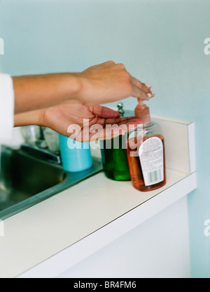 Femme à l'aide d'un désinfectant pour les mains Banque D'Images
