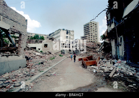 Les enfants courir à travers les dommages causés par les bombes de l'OTAN à Pristina au Kosovo. Banque D'Images