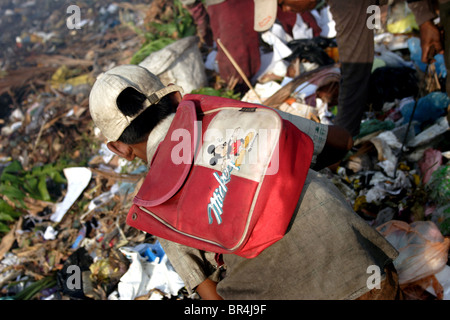 Un jeune garçon enfant travailleur porte un sac à dos Mickey Mouse à la décharge de Stung Meanchey à Phnom Penh, Cambodge. Banque D'Images