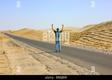 Touristiques de l'ouest sur l'autoroute, Reed fait holding sand clôture pour empêcher la désertification le long de la freeway, Aksu, Xinjiang, Chine Banque D'Images