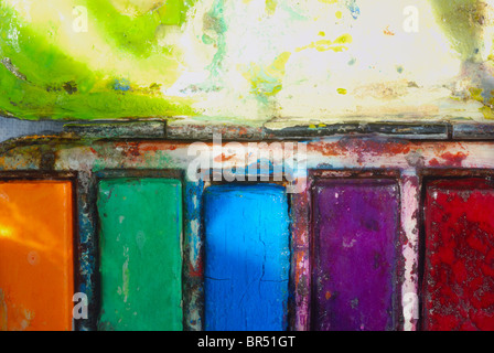 Vintage de l'artiste utilisé l'aquarelle, paintbox big close up sur l'orange, vert, bleu, violet et rouge et le mélange de blocs de palette. Banque D'Images