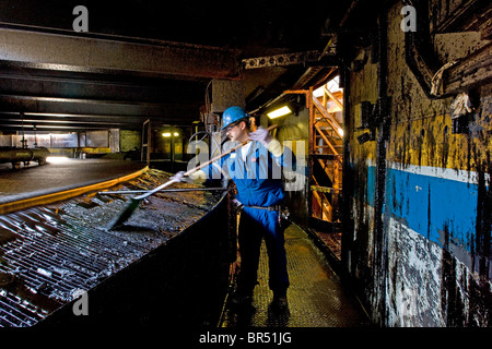 Travailleur avec du bitume dans une usine d'extraction installation Suncor au nord de Fort McMurray Alberta Canada. Banque D'Images