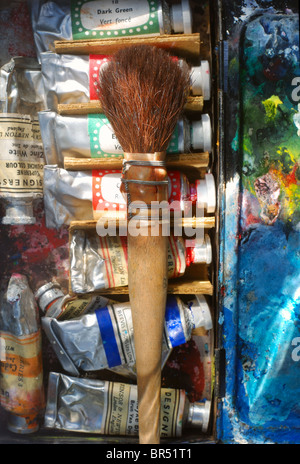 Objets decoratifs de blaireau d'artiste sur une boîte de peinture aquarelle utilisé avec des tubes de peinture et le mixage de palette. Banque D'Images