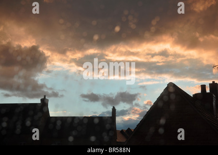 La pluie sur la fenêtre regardant le ciel orageux au développement du logement à Witney Banque D'Images