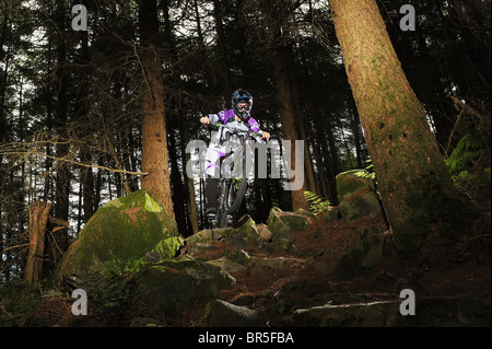 Une descente en vélo de montagne sur les rochers, entre les arbres dans la foresterie. Banque D'Images