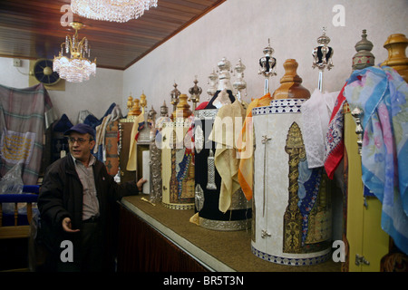 Le concierge de Gan Eden Synagogue à Stamford Hill d'engloutir l'un des rouleaux de la Torah richement décorées à l'intérieur de l'arche. Banque D'Images