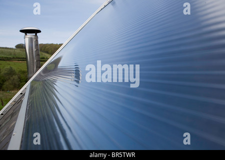 Un panneau solaire thermique sur le toit. Les chauffe-eau solaires utilisent la chaleur du soleil pour travailler aux côtés de chauffe-eau conventionnels. Banque D'Images