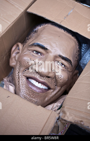 Barack Obama, un masque dans une boîte carton. Banque D'Images