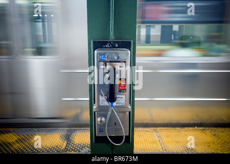 Un téléphone payant public fonctionnant avec des pièces sur la plate-forme de la station de métro Sheridan Square à New York Banque D'Images