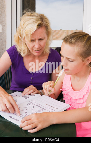 Mère et fille faisant livre-puzzle ensemble. Banque D'Images