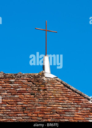 Croix en fer forgé brut sur toit de maison - France. Banque D'Images