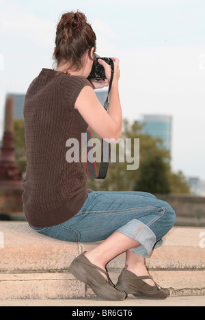 Une fine brunette woman taking photos contre une ville Banque D'Images