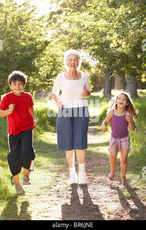 Grand-mère le jogging dans le parc avec petits-enfants Banque D'Images