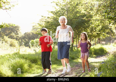 Grand-mère le jogging dans le parc avec petits-enfants Banque D'Images