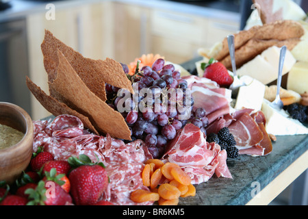 Sélection de charcuterie, de fromages et de fruits sur un comptoir de cuisine Banque D'Images