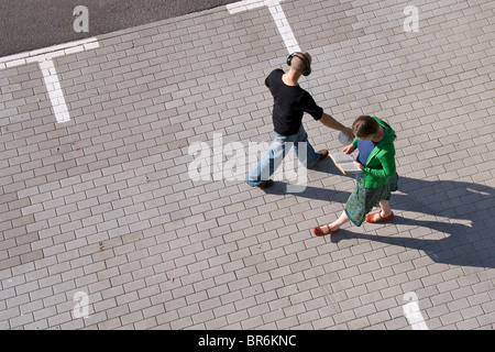 Deux inconnus se croisent en se promenant dans un parc de stationnement Banque D'Images