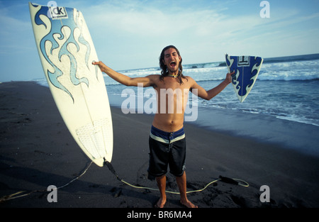 Un surfeur mâle crie et peut contenir jusqu'sa fracture de surf sur la plage. Banque D'Images