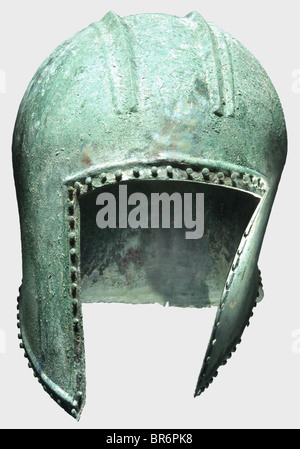 Un casque Illyrian, 6ème siècle avant J.-C. Bronze. Crâne sphérique avec large base de crête, avec deux crêtes, des découpes latérales peu profondes et un protège-cou court. Entouré d'une double bordure relevée, renforcée sur le front, avec des épingles décoratives à tête de lentille. Les bouts des morceaux de cheekpiered pour la fixation de la mentonnière. Hauteur 23 cm, poids 670 g. Légèrement déformée, métal en bon état, patine bleu-vert avec des dimensions du sol. L'intérieur, au-dessus de la découpe du visage, à l'arrière de la crête, sur le côté gauche et au cou (fissure de 3,5 cm de long) sta, Banque D'Images