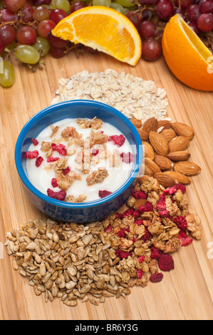 Un bol de yaourt frais avec des fruits frais et sains ajouts comme les amandes, d'avoine, céréales et graines de tournesol Banque D'Images