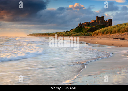 Château de Bamburgh au lever du soleil sur la côte est de Northumberland, Angleterre. Banque D'Images