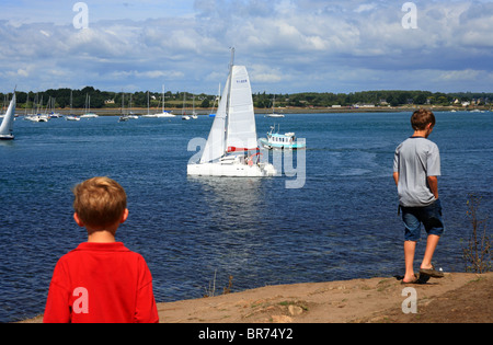 Les garçons à la recherche sur les bateaux de la pointe de Toulindac à Port Blanc, l'Ile aux Moines, Golfe du Morbihan, Bretagne, Bretagne, France Banque D'Images