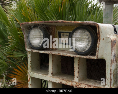 Détail de l'avant avec les phares d'un tracteur Oliver antiques avec les feuilles de palmier derrière Carpinteria, en Californie, USA. Banque D'Images