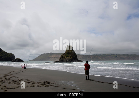 Les gens de la pêche maritime à Whatipu Beach dans le Waitakare Parc régional varie, en Nouvelle-Zélande. Banque D'Images