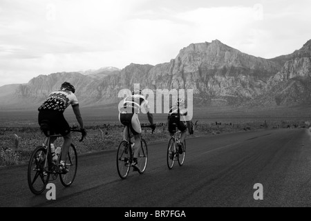 Trois coureurs descendant la route panoramique dans le Red Rock Canyon de conservation. Banque D'Images