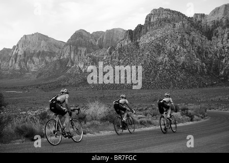 Trois coureurs descendant la route panoramique dans le Red Rock Canyon de conservation. Banque D'Images