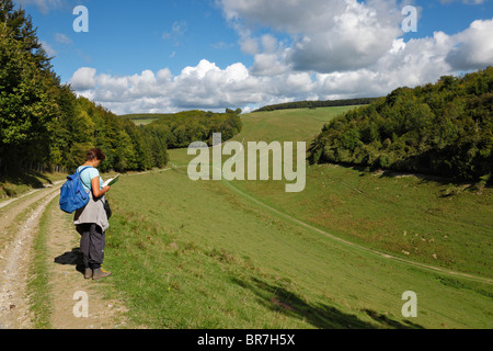 Femme lisant un plan guide marche sur les South Downs. Banque D'Images