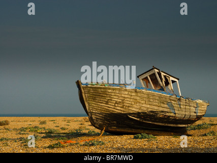 Vieux bateau abandonné sur la plage de dormeur, contre un ciel orageux gris. Banque D'Images