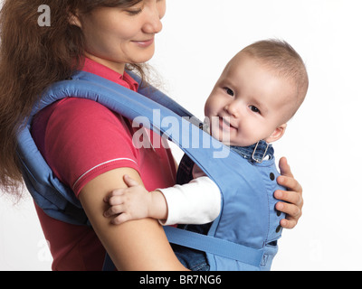 Mère avec un bébé de quatre mois garçon dans un transporteur. Isolé sur fond blanc. Banque D'Images