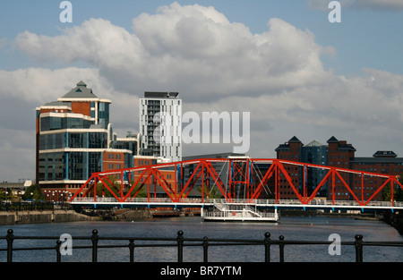 Vue d'immeubles de bureaux modernes et les appartements de Salford Quays, Manchester, Angleterre avec pont rouge au premier plan. Banque D'Images