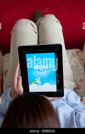 Femme à l'aide de l'ordinateur tablette iPad pour faire appel à l'aide d'un service de téléphonie sur Internet Skype Banque D'Images