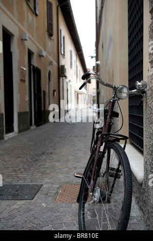 Bicycle leaning against wall dans la ville d'Iseo, Italie du nord. Banque D'Images