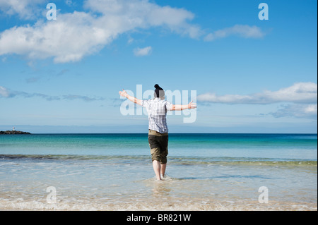 Personne marche dans l'eau froide de la plage de sable blanc, Gimsøya, îles Lofoten, Norvège Banque D'Images