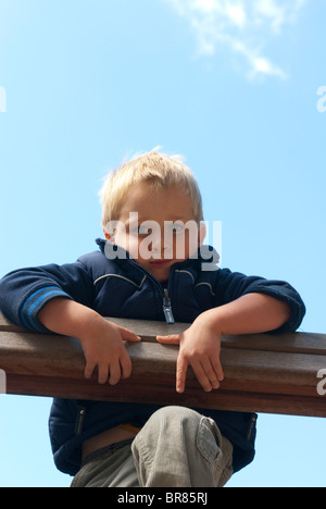 Un jeune garçon blond 4 ans sur une aire d'été Banque D'Images