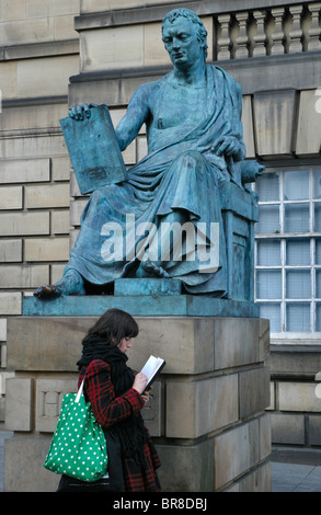 Croquis d'une fille à côté de la statue de David Hume sur la High Street à Édimbourg, en Écosse. Banque D'Images