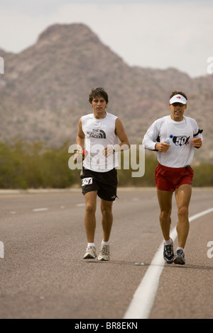 Deux coureurs courir le long d'une route au cours d'un marathon à surprise en Arizona. Banque D'Images