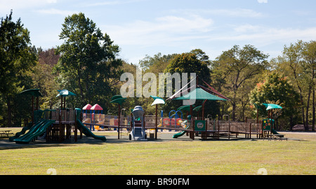 Aire de jeux pour enfants moderne dans parc verdoyant avec des diapositives et des portiques Banque D'Images