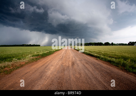 Un chemin de terre mène à l'arcus cloud d'un violent orage dans le nord de l'Oklahoma, le 12 mai 2010. Banque D'Images