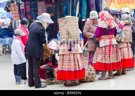 Les femmes Hmong fleurs l'achat de poulets au marché du dimanche de Bac Ha, Vietnam Banque D'Images