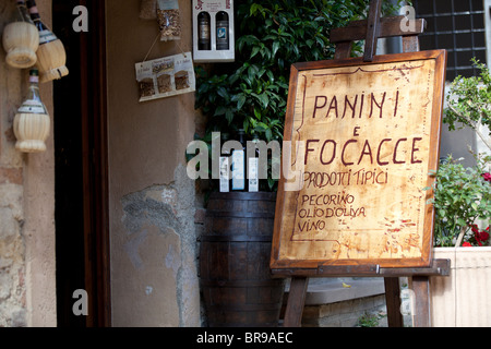 Un panneau publicitaire panini's exposé à l'extérieur d'une petite boutique dans une ville toscane au sommet d'une colline juste à l'extérieur de San Gimignano, en Toscane Italie Banque D'Images