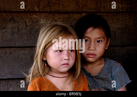 Deux jeunes filles hmongs vous détendre sur la véranda de leur maison à seulement 15 kilomètres de Luang Prabang, Laos. Banque D'Images