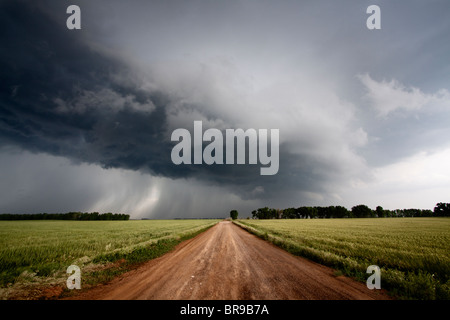 Un chemin de terre mène à l'arcus cloud d'un violent orage dans le nord de l'Oklahoma, le 12 mai 2010. Banque D'Images